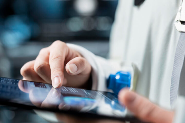 Close up of astronaut reviewing spacecraft metrics on tablet
