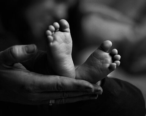 Black and white photography of newborn's small feet, symbolizing the fragility of life created through in vitro technologies